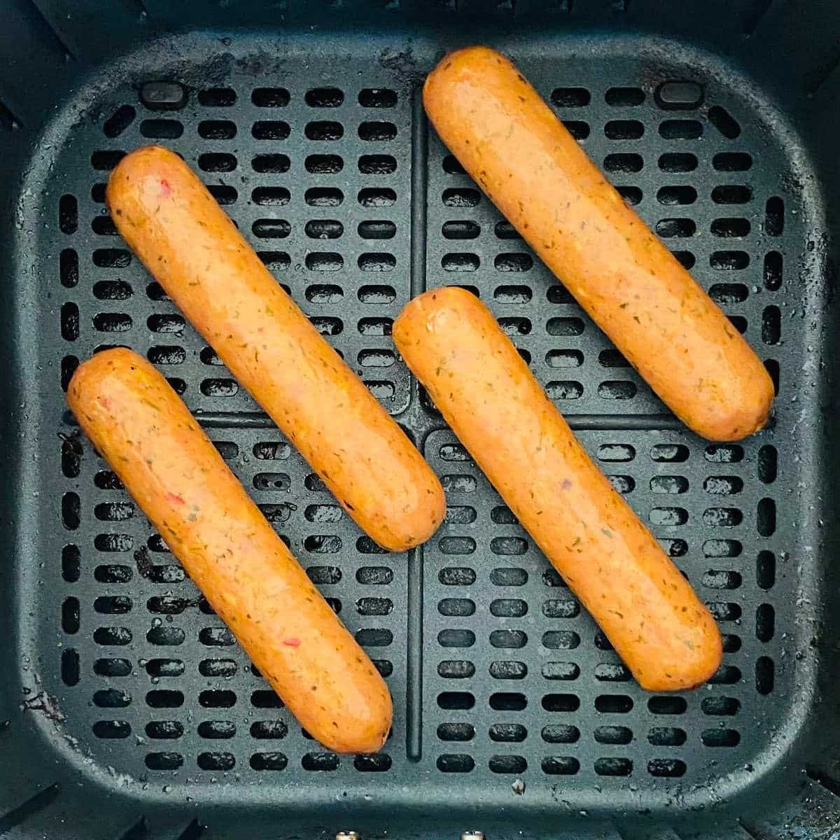 chicken sausage in air fryer basket.