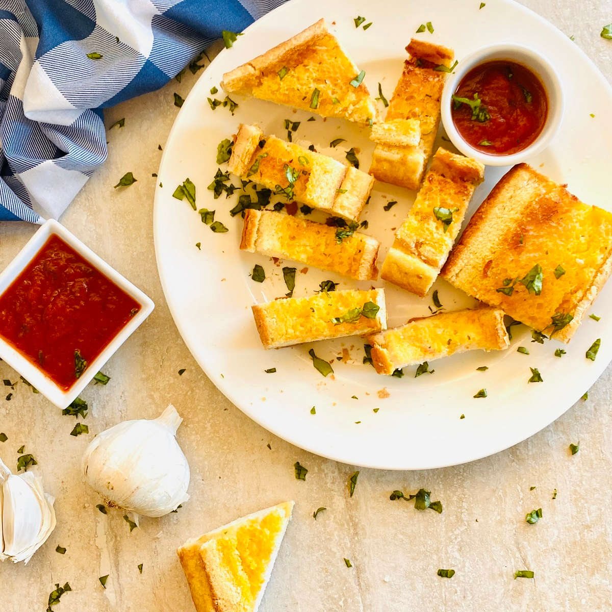 air fryer frozen garlic bread cooked on a plate next to spaghetti sauce