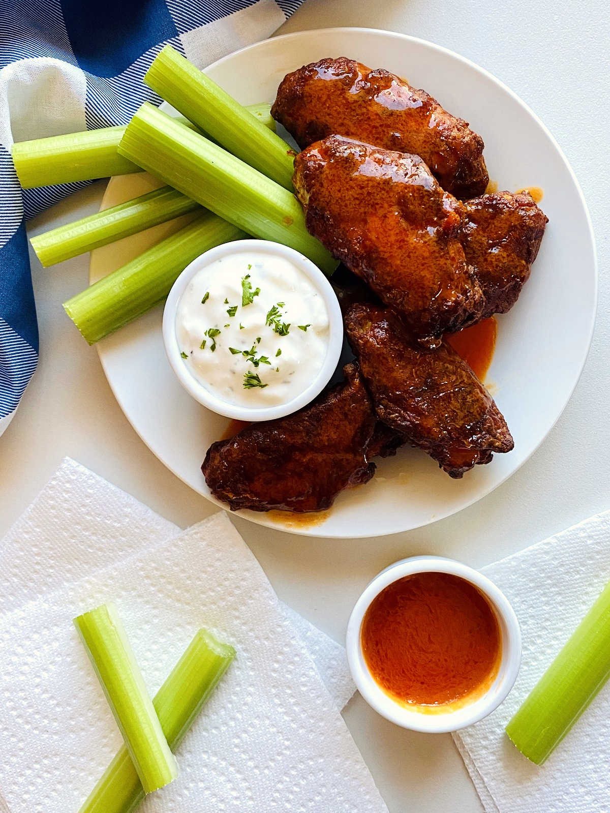 air fryer chicken wings on a plate next to celery and blue cheese