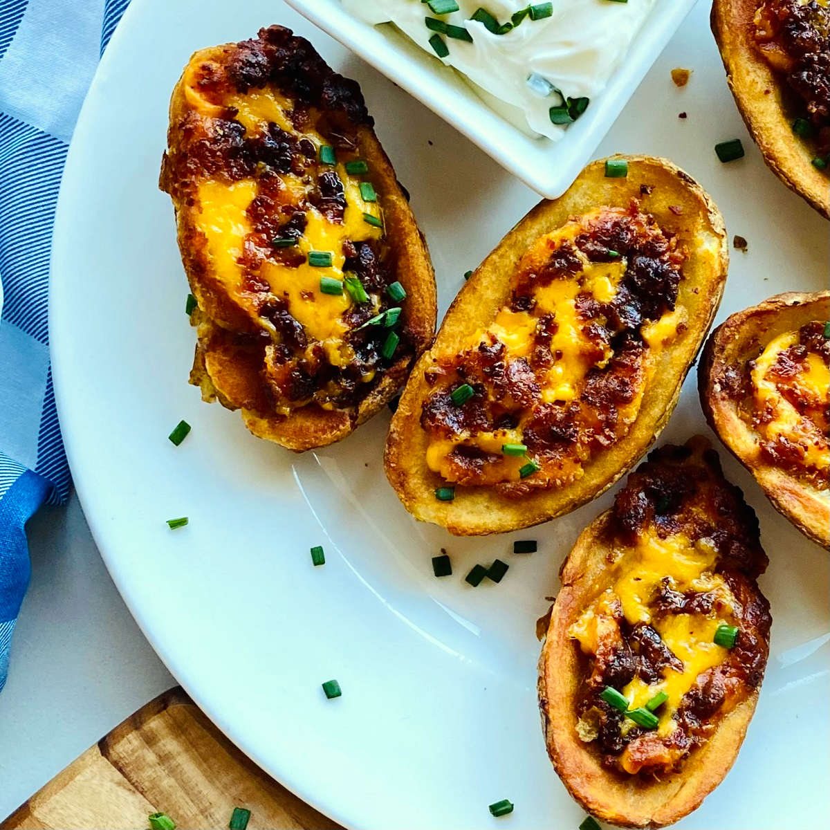 air fryer potato skins on plate with sour cream and chives