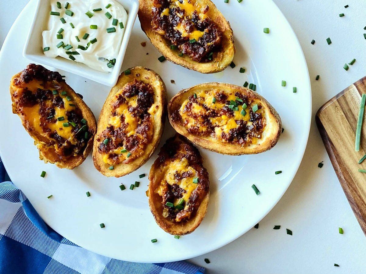 air fryer potato skins on plate next to sour cream