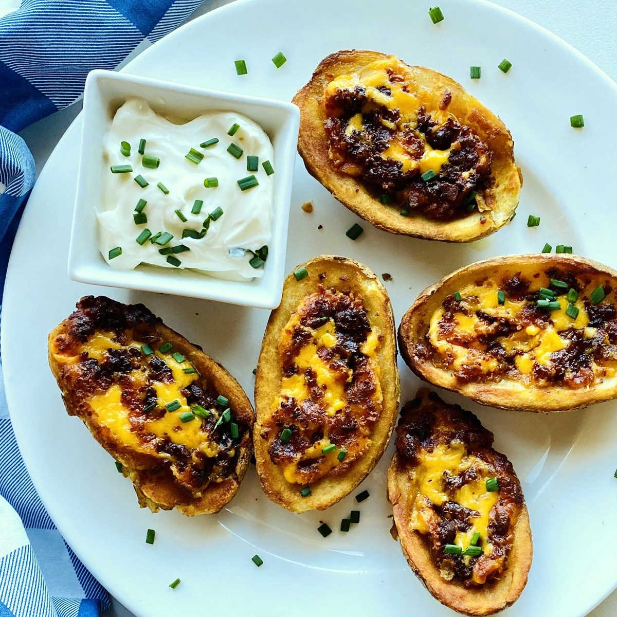 air fryer potato skins on plate next to sour cream