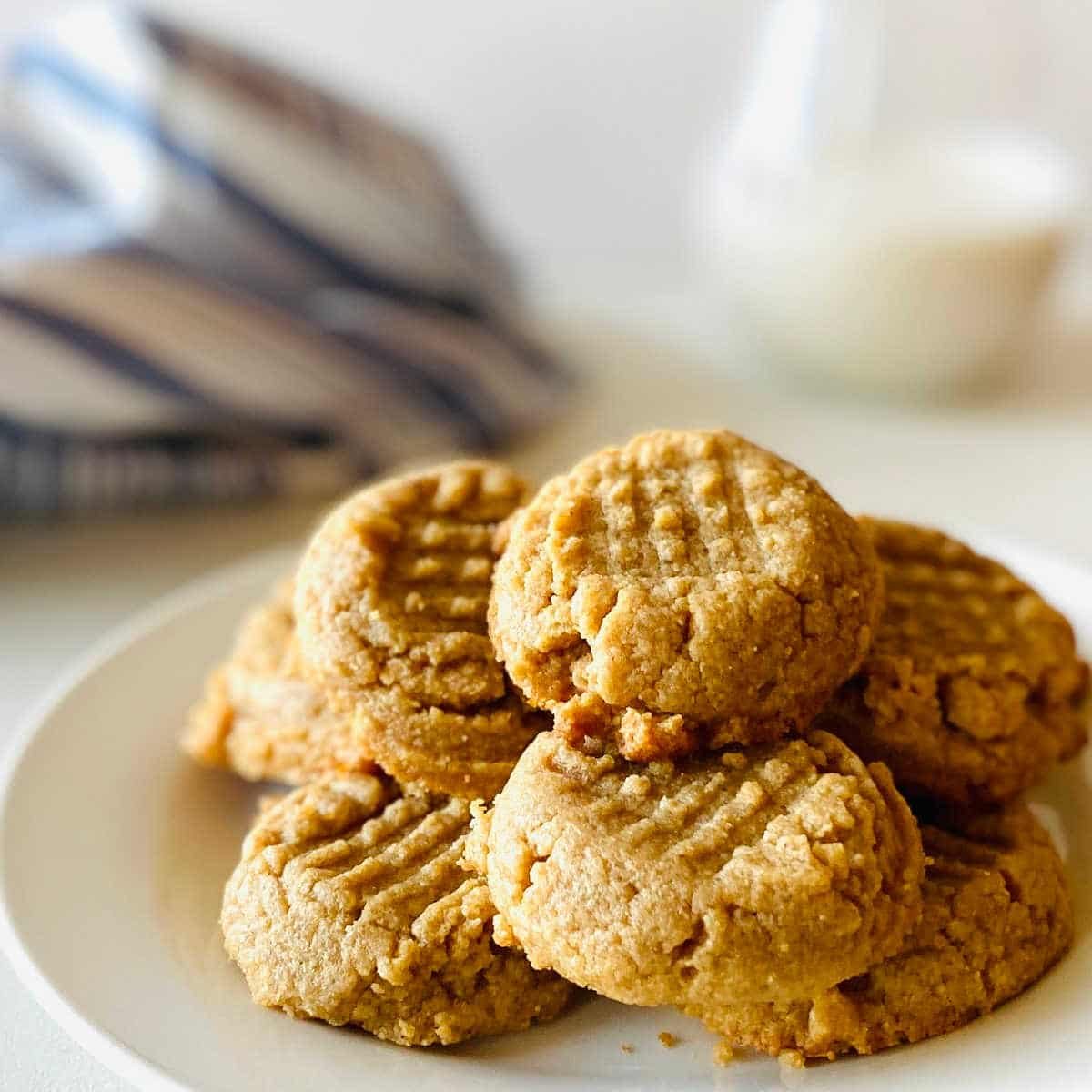 almond flour peanut butter cookies on plate next to glass of milk