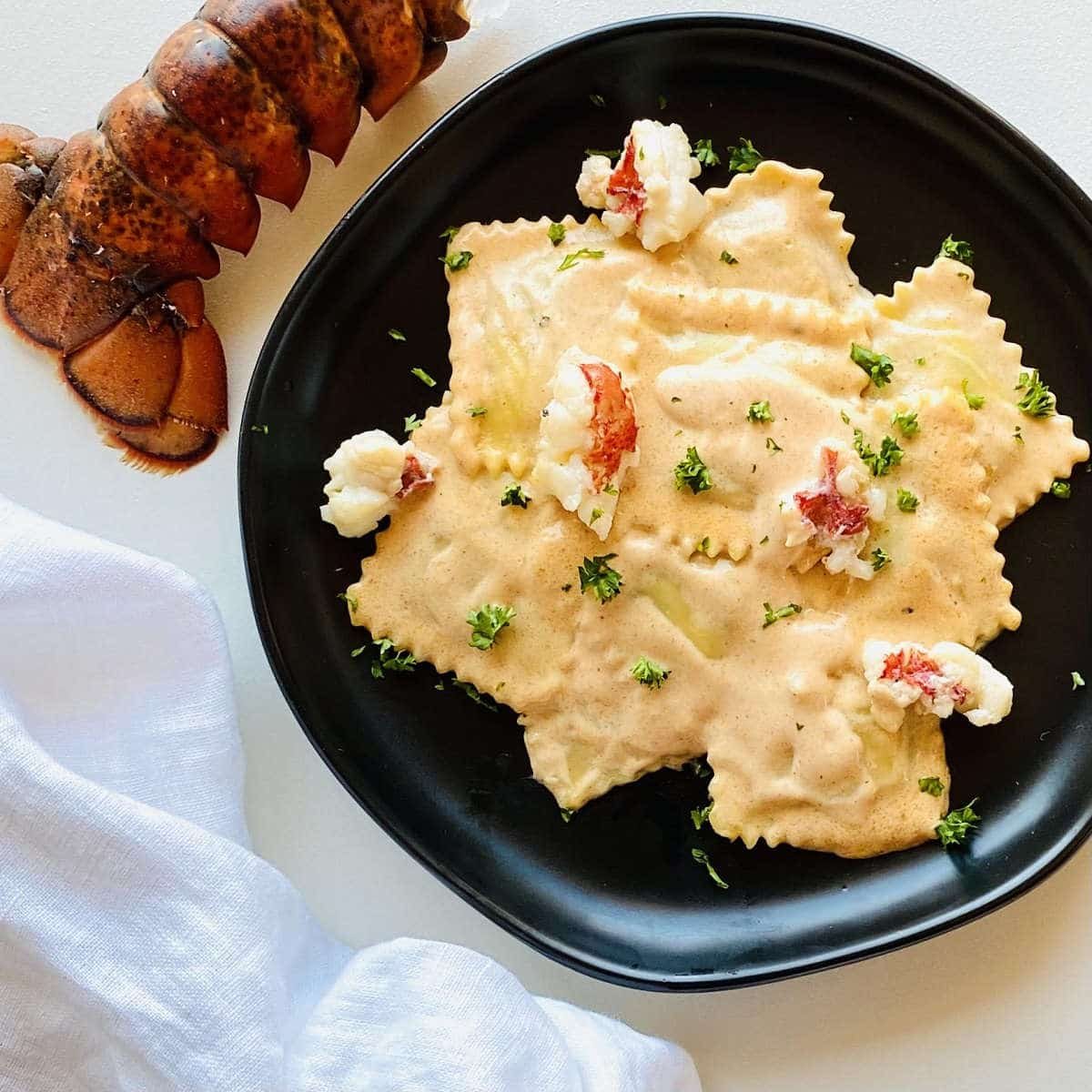 sauce for lobster ravioli served over lobster ravioli next to a lobster tail