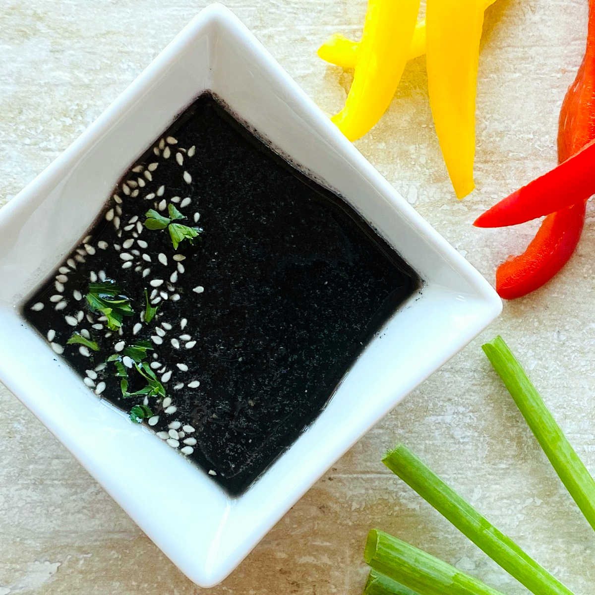 black sesame paste tahini in dish next to vegetables