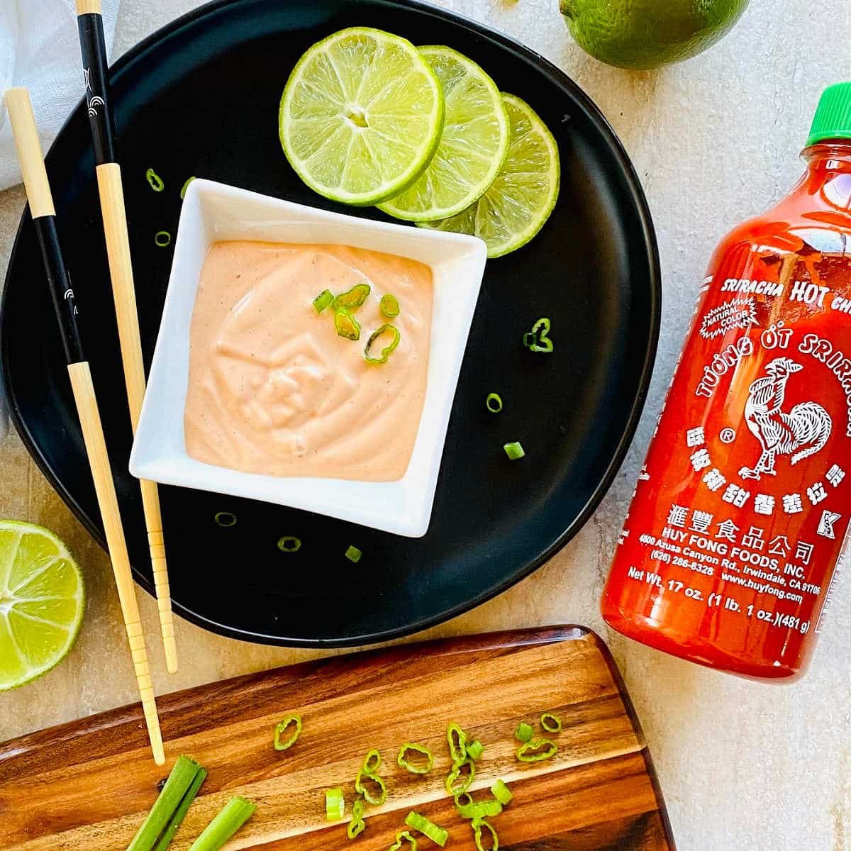 sriracha aioli recipe in a dish next to a bottle of Huy Fong Sriracha Hot Chile Sauce.