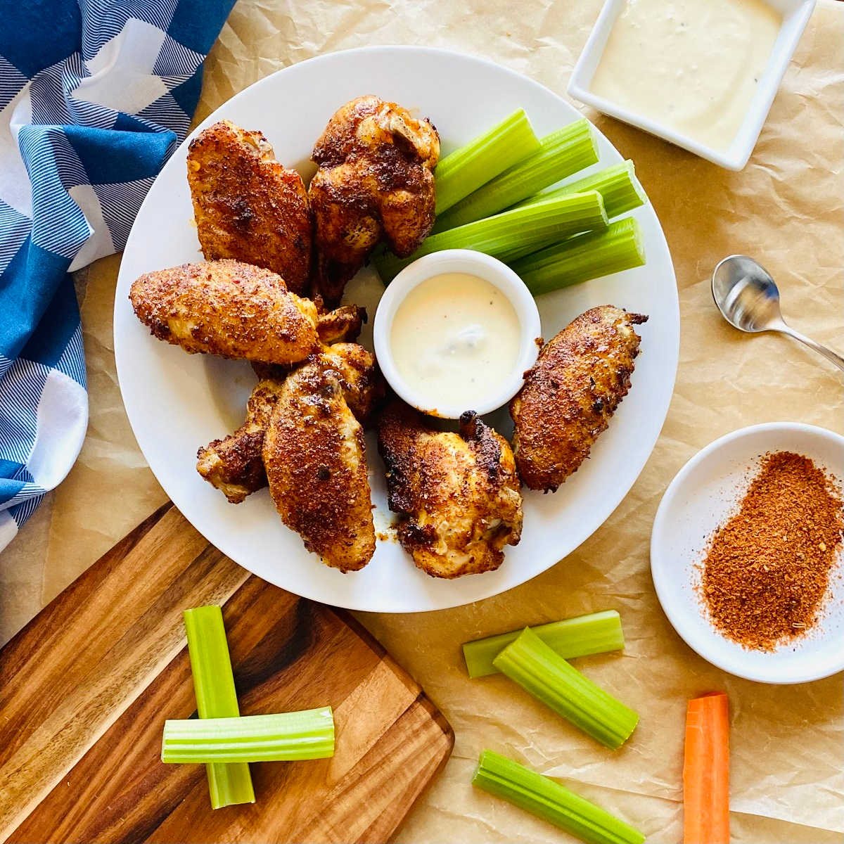 cajun dry rub wings on a plate with celery, carrots and blue cheese