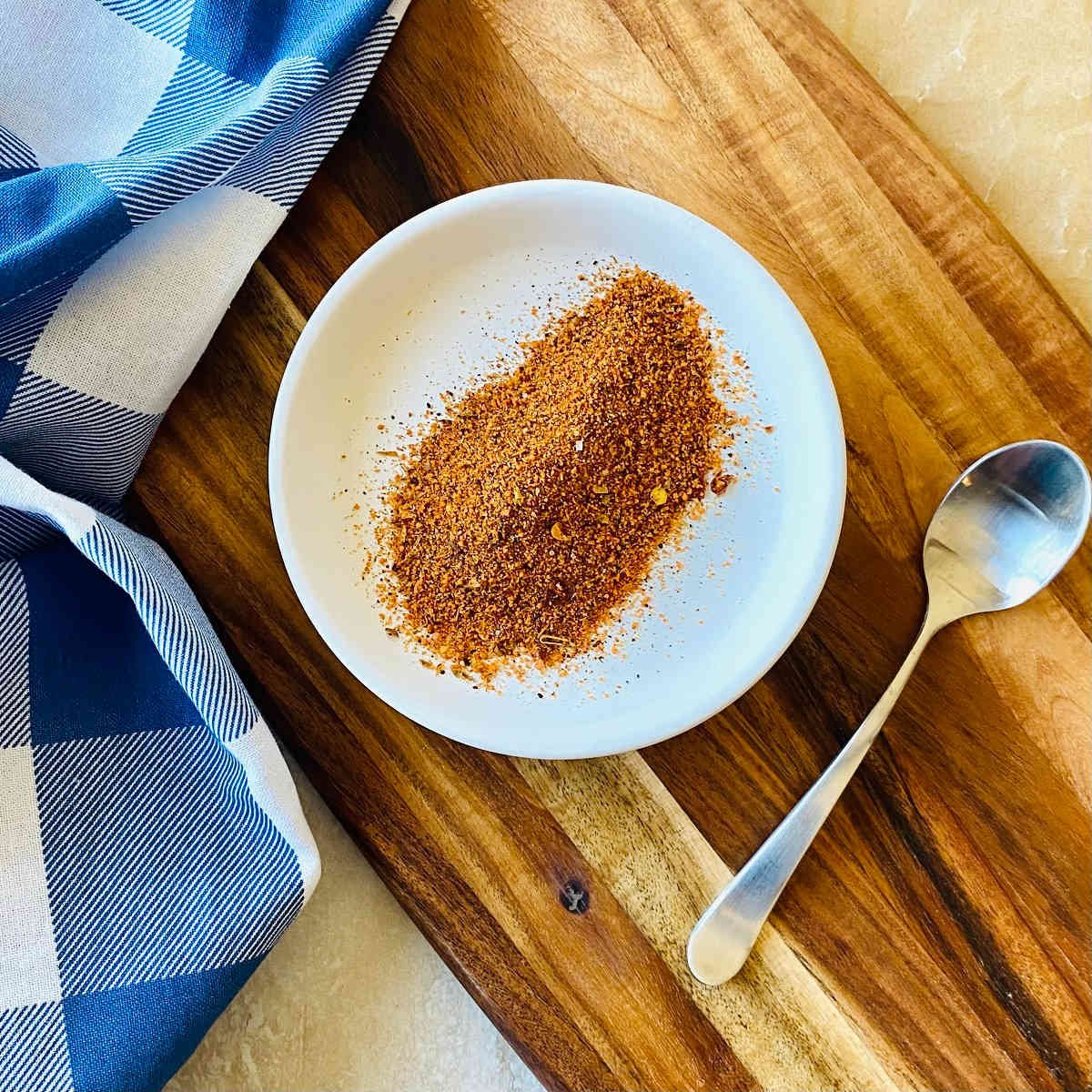 chicken wing rub on a plate with a spoon on the side