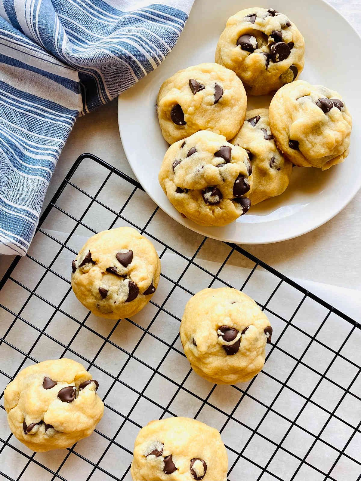 chocolate cookies without brown sugar on a plate next to cooling rack of cookies