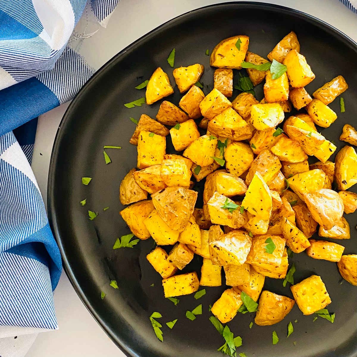 air fryer diced potatoes on a plate with parsley garnish