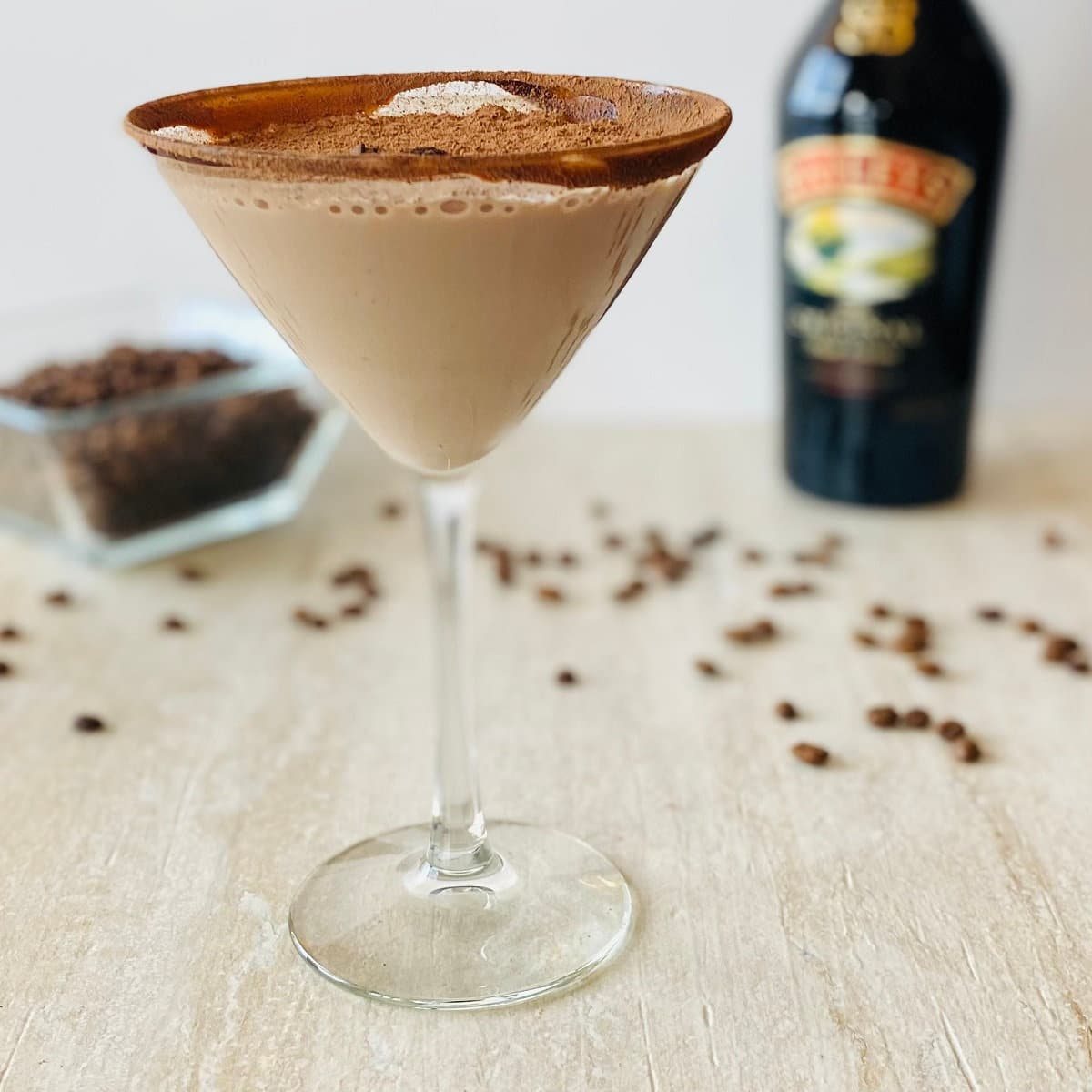 mr black espresso martini in martini glass with baileys and espresso beans in the background