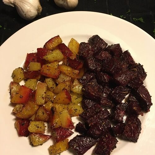 Herb Garlic Roasted Beets on white plate with 2 heads of garlic in the background