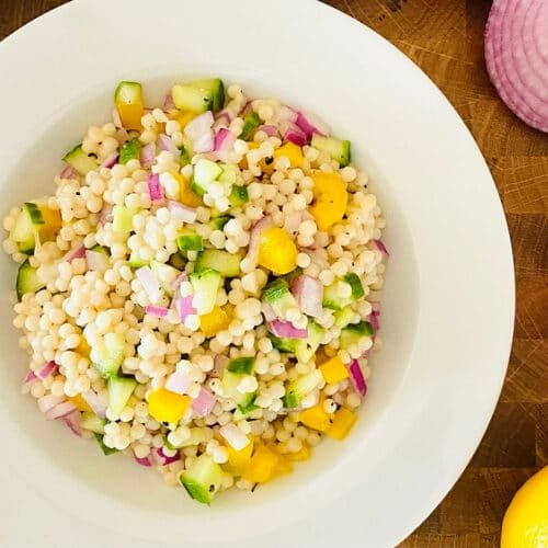 instant pot couscous next to blue napkin, tomato and lemon