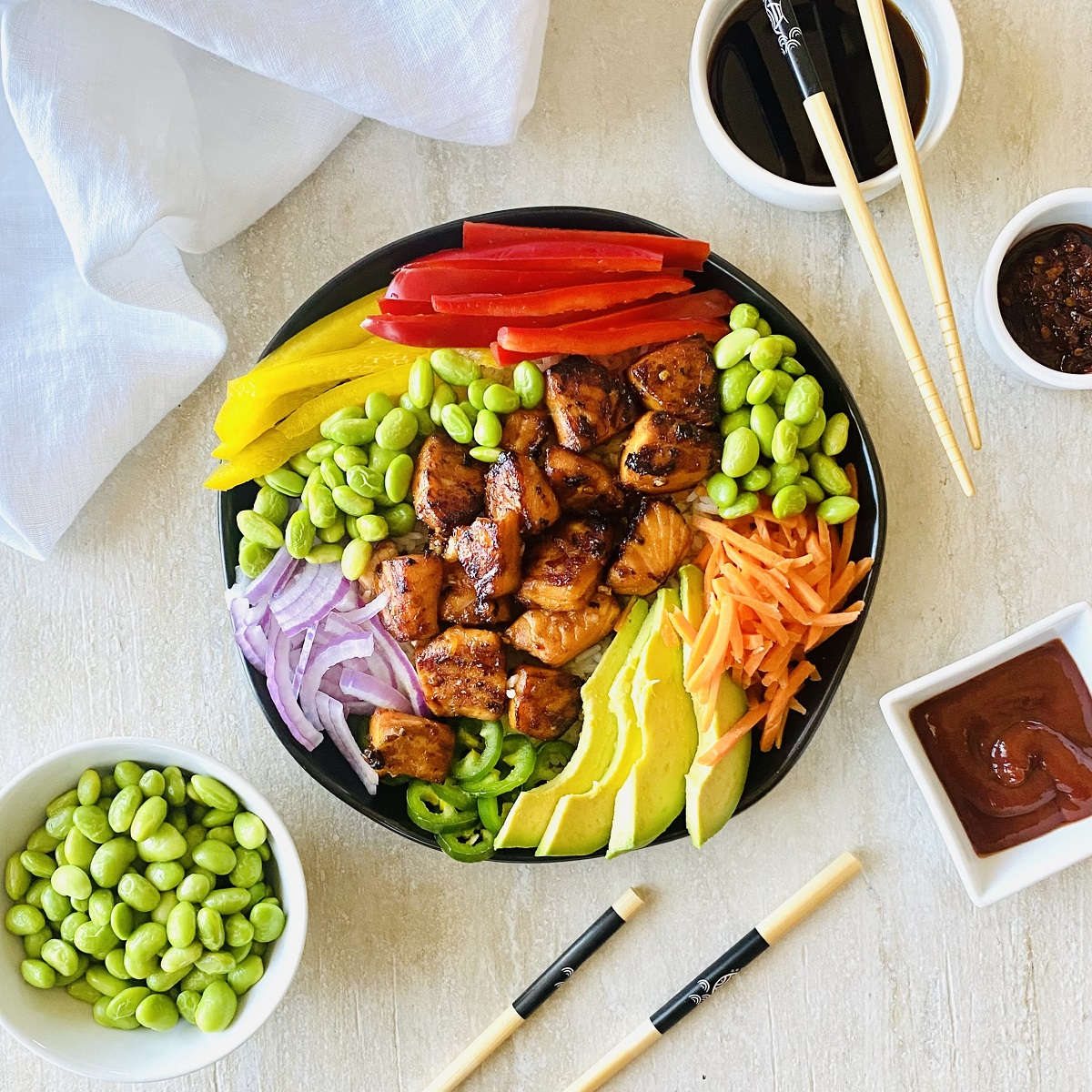 spicy salmon bowl with sriracha, soy sauce, chili oil and edamame