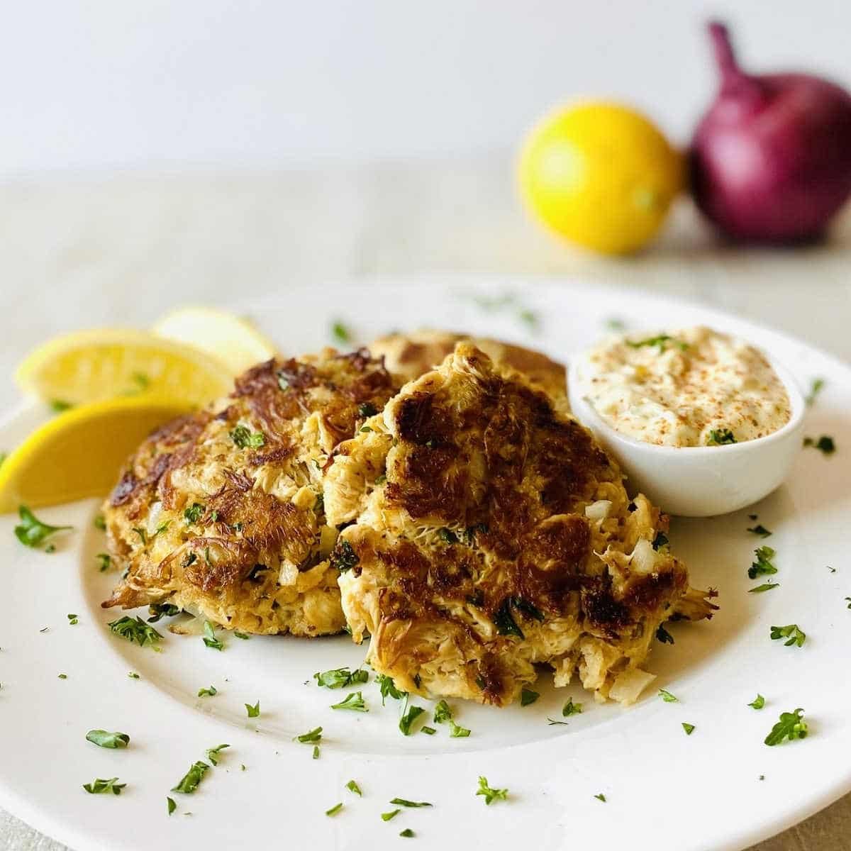 lions mane mushroom crab cakes on plate with lemon and tartar sauce