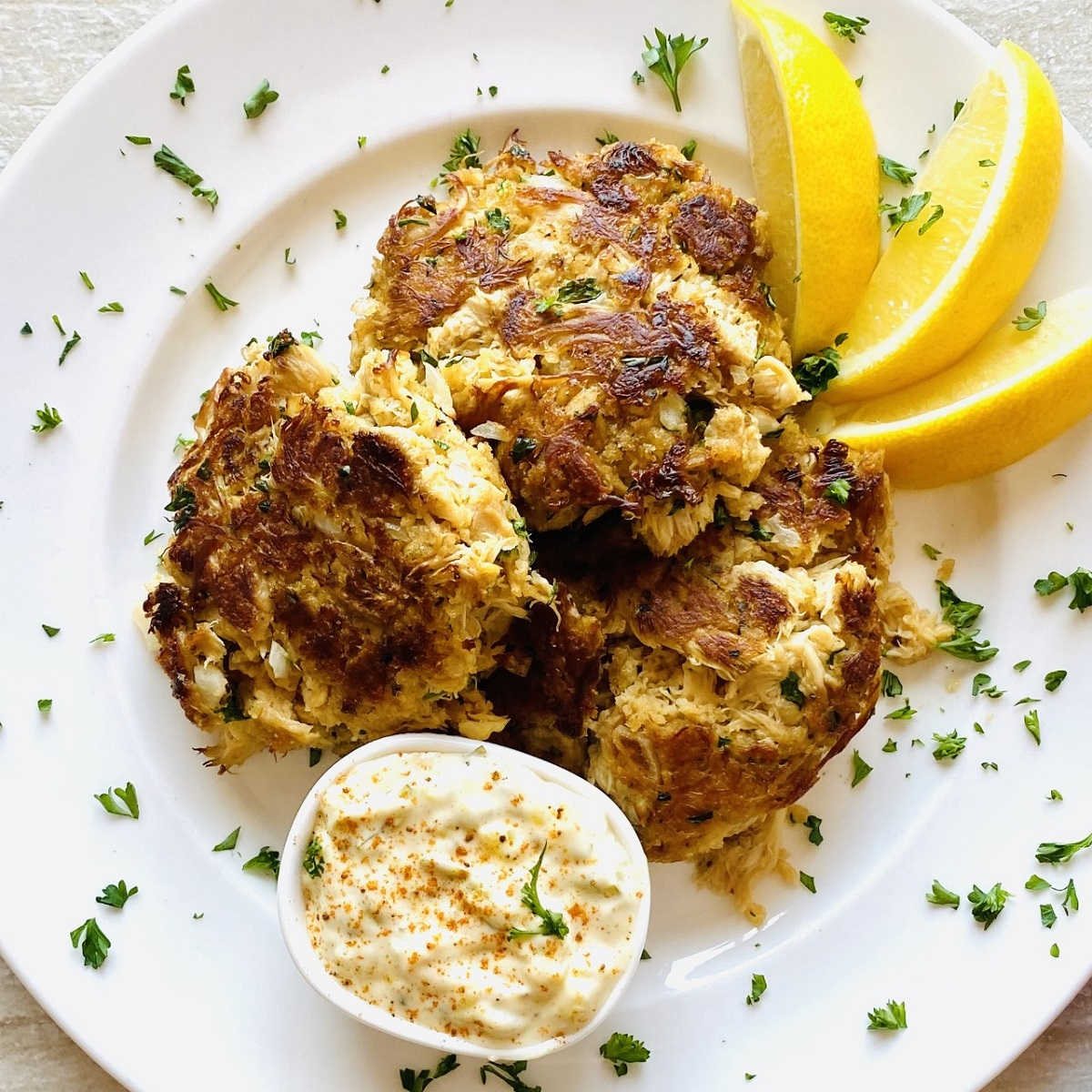 lions mane mushroom crab cakes on plate with lemon and tartar sauce