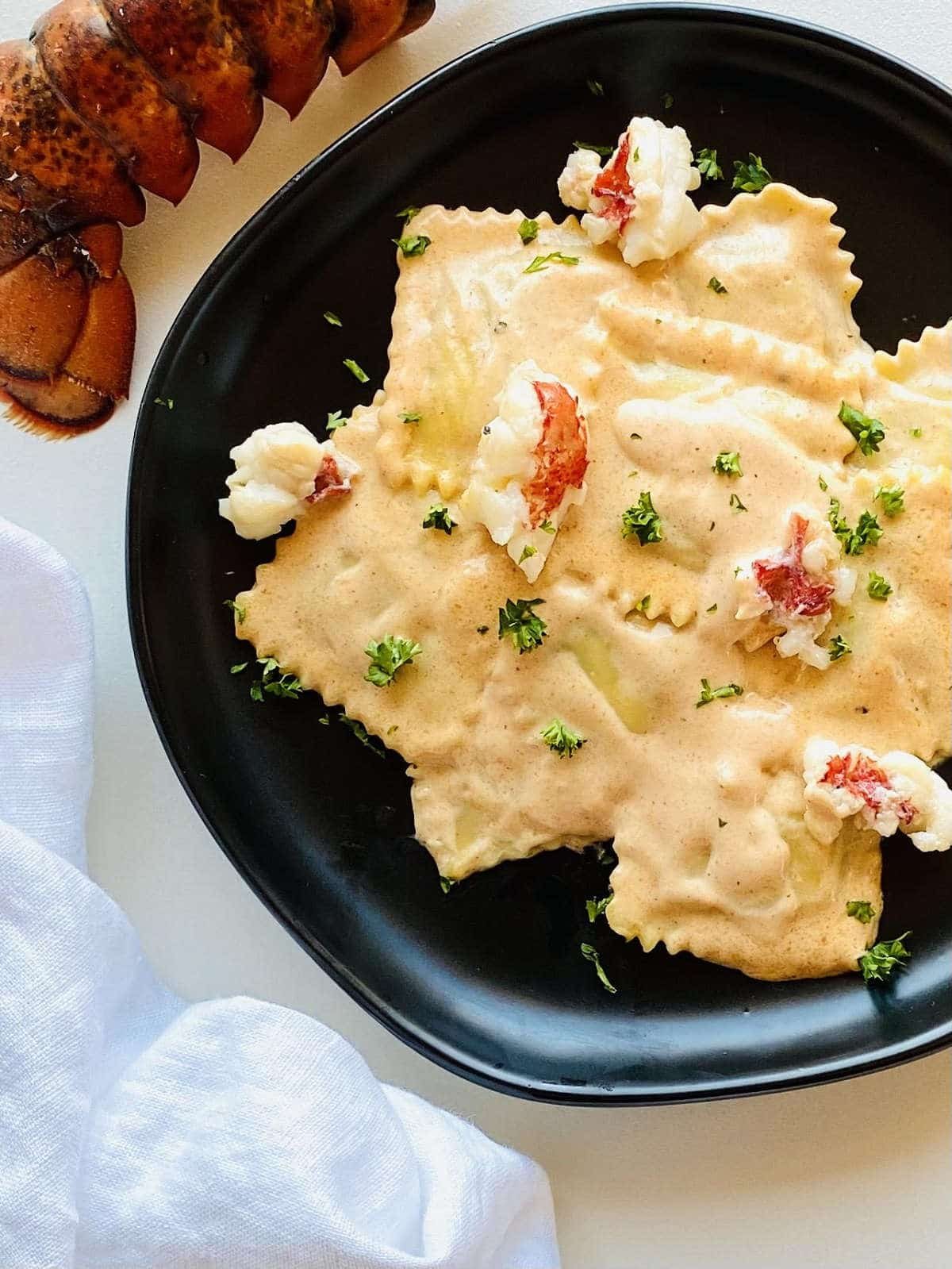 lobster ravioli sauce served over lobster ravioli next to a lobster tail