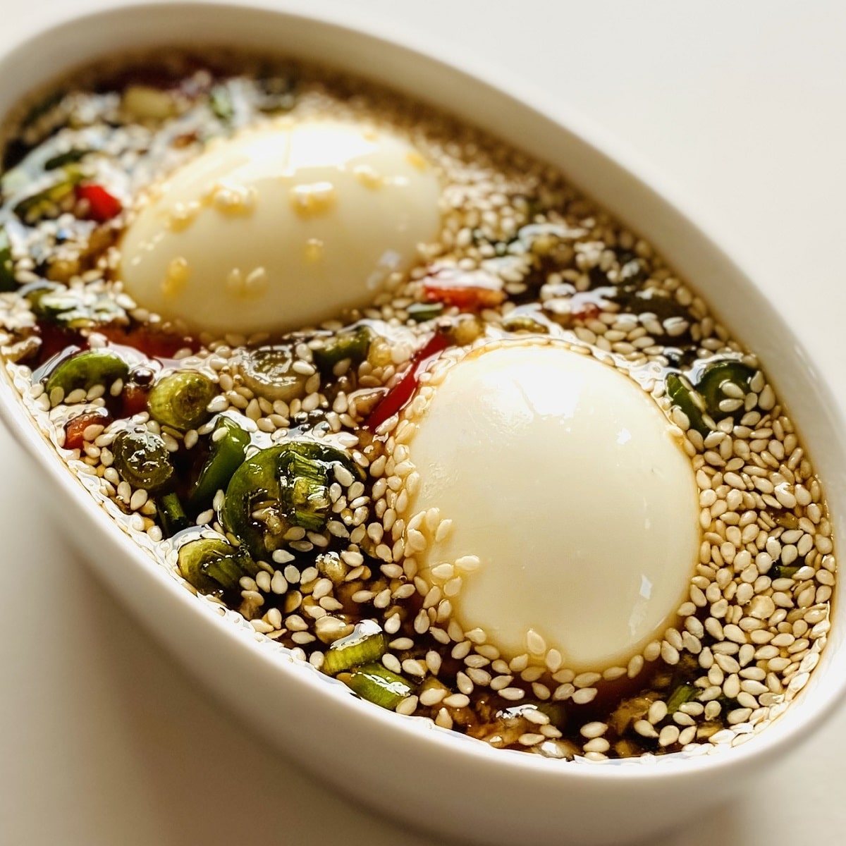 mayak eggs marinating in white dish of sauce
