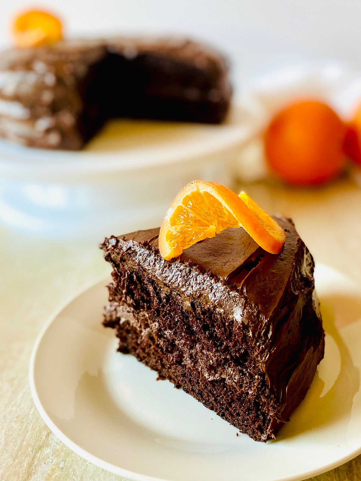 orange chocolate cake on a white plate garnished with a candied orange slice on top