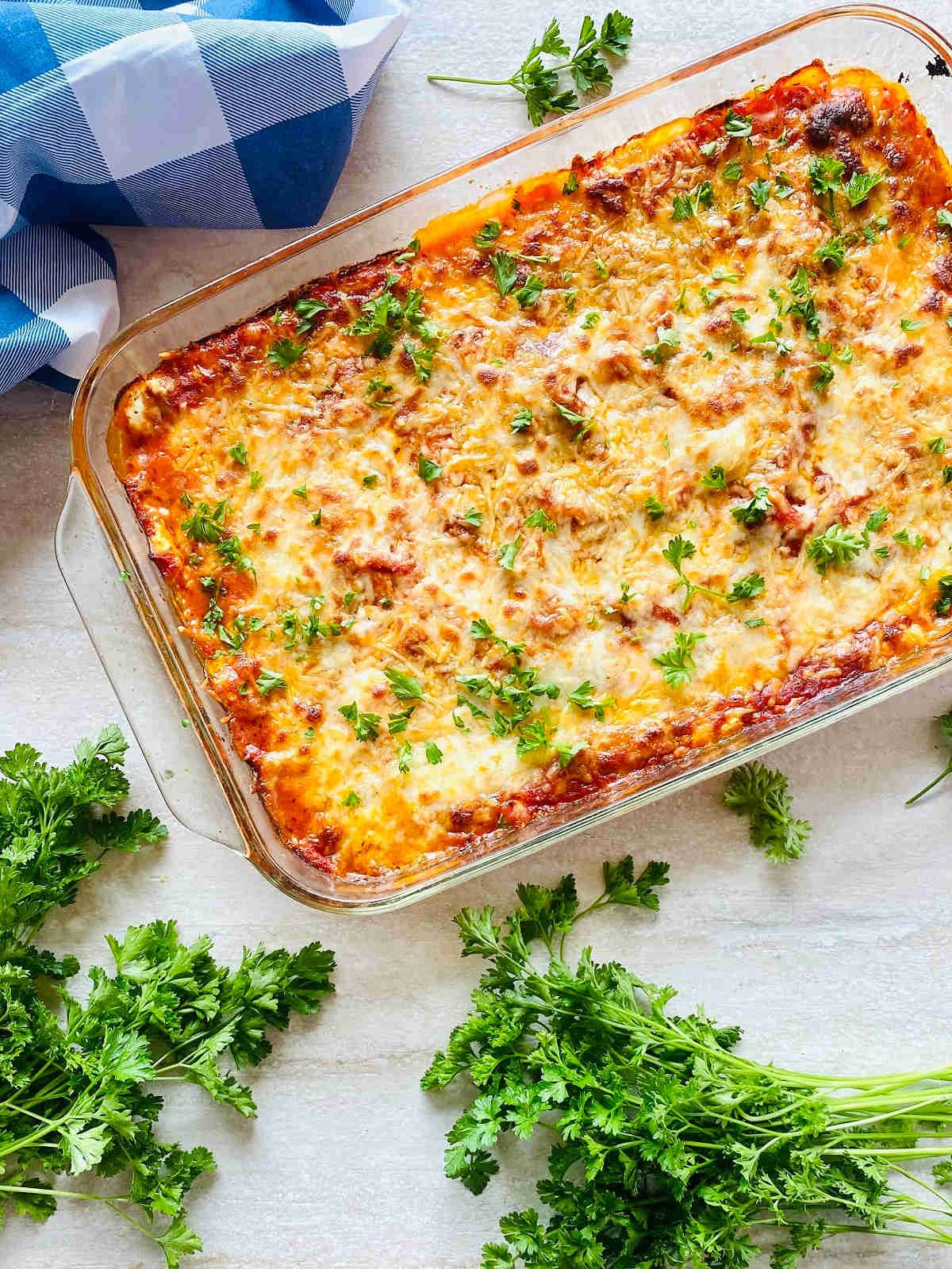 hearts of palm lasagna in a baking dish next to fresh parsley