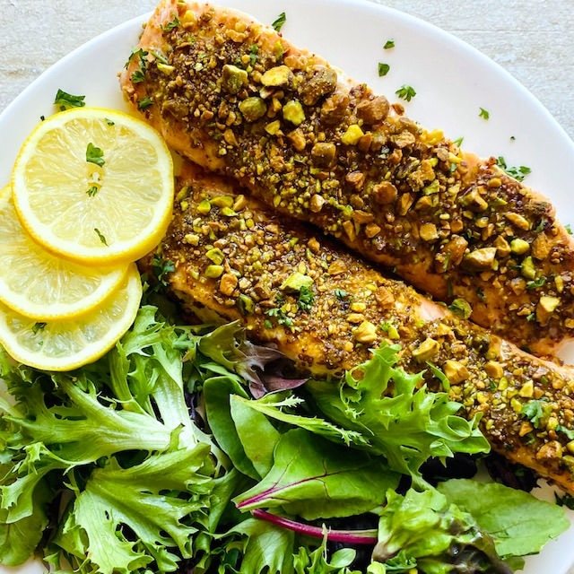 pistachio-crusted-salmon-on-plate-with-lemons-and-greens