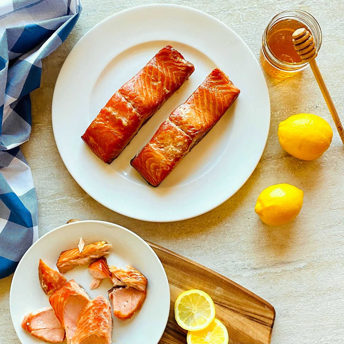 honey smoked salmon on a plate next to honey and lemons