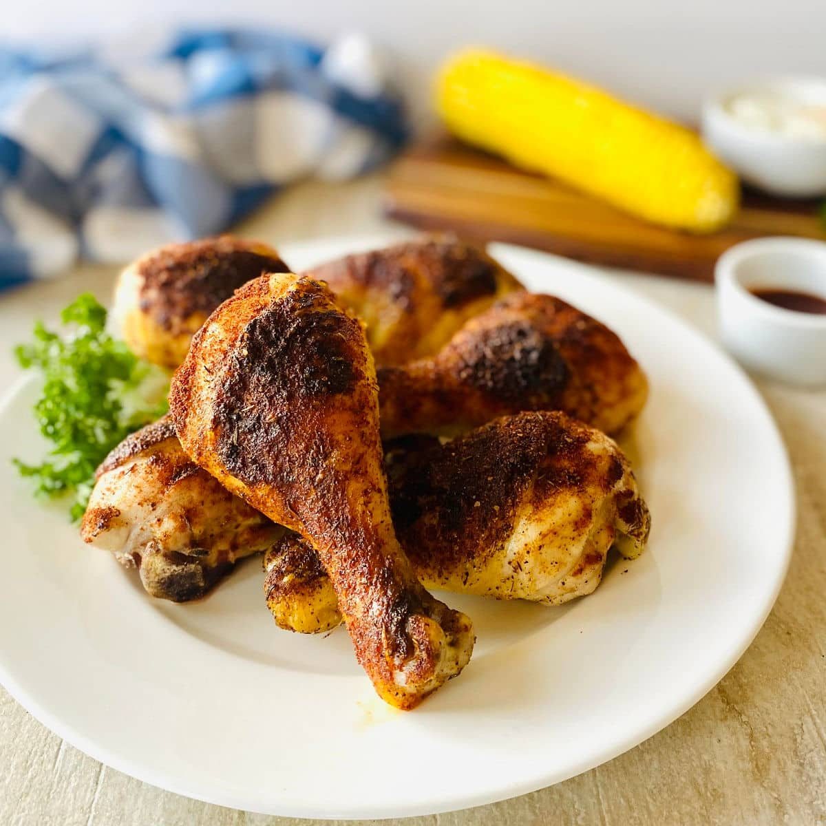 pitboss Smoked Chicken Legs on plate with corn.