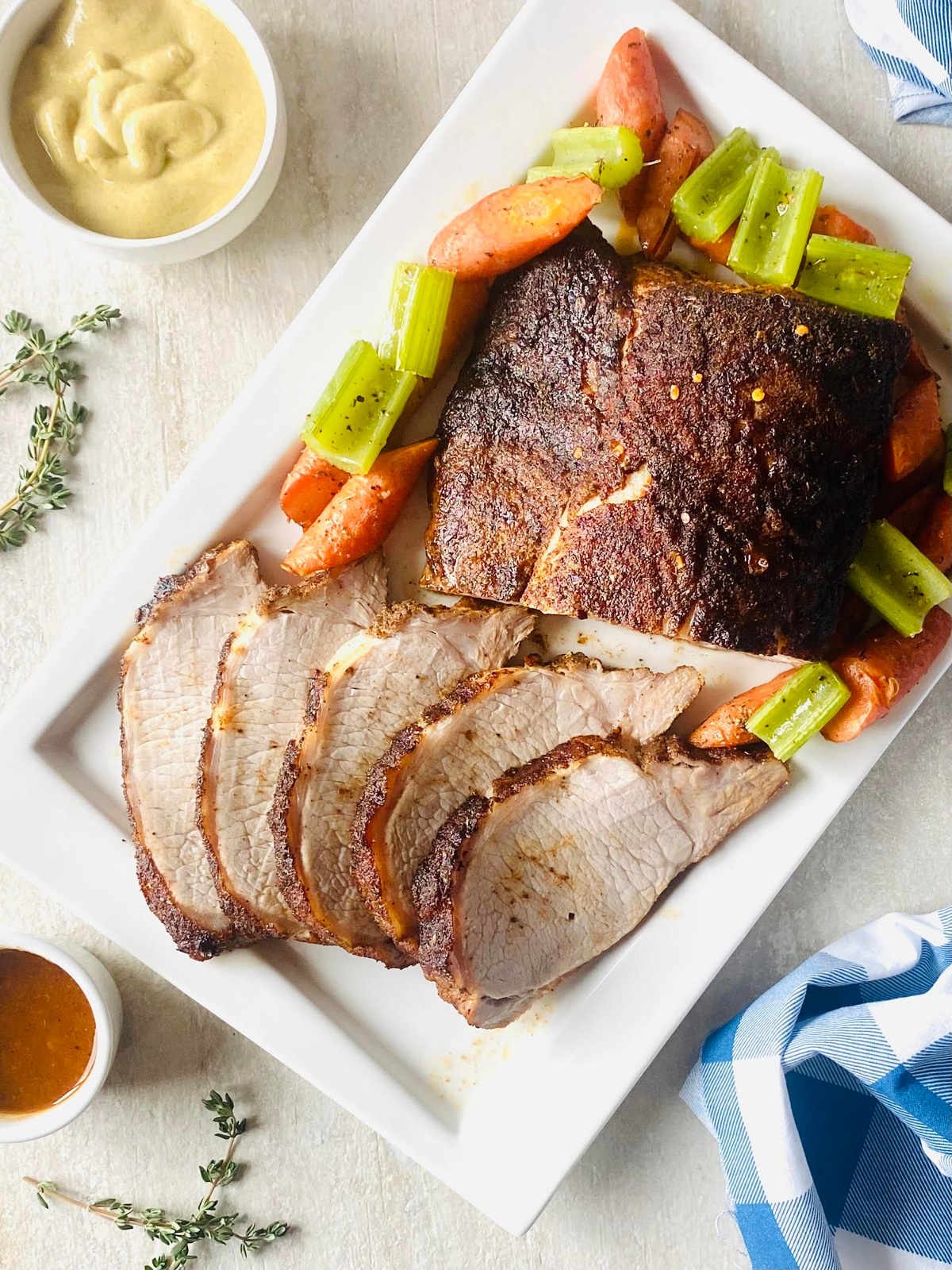 pit boss pork loin on plate surrounded by roasted vegetables.