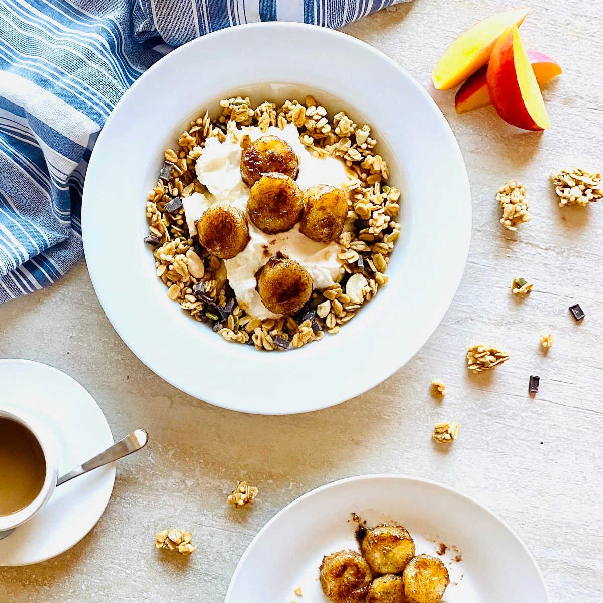 air fried bananas in a bowl with yogurt and granola next to bananas and nectarines