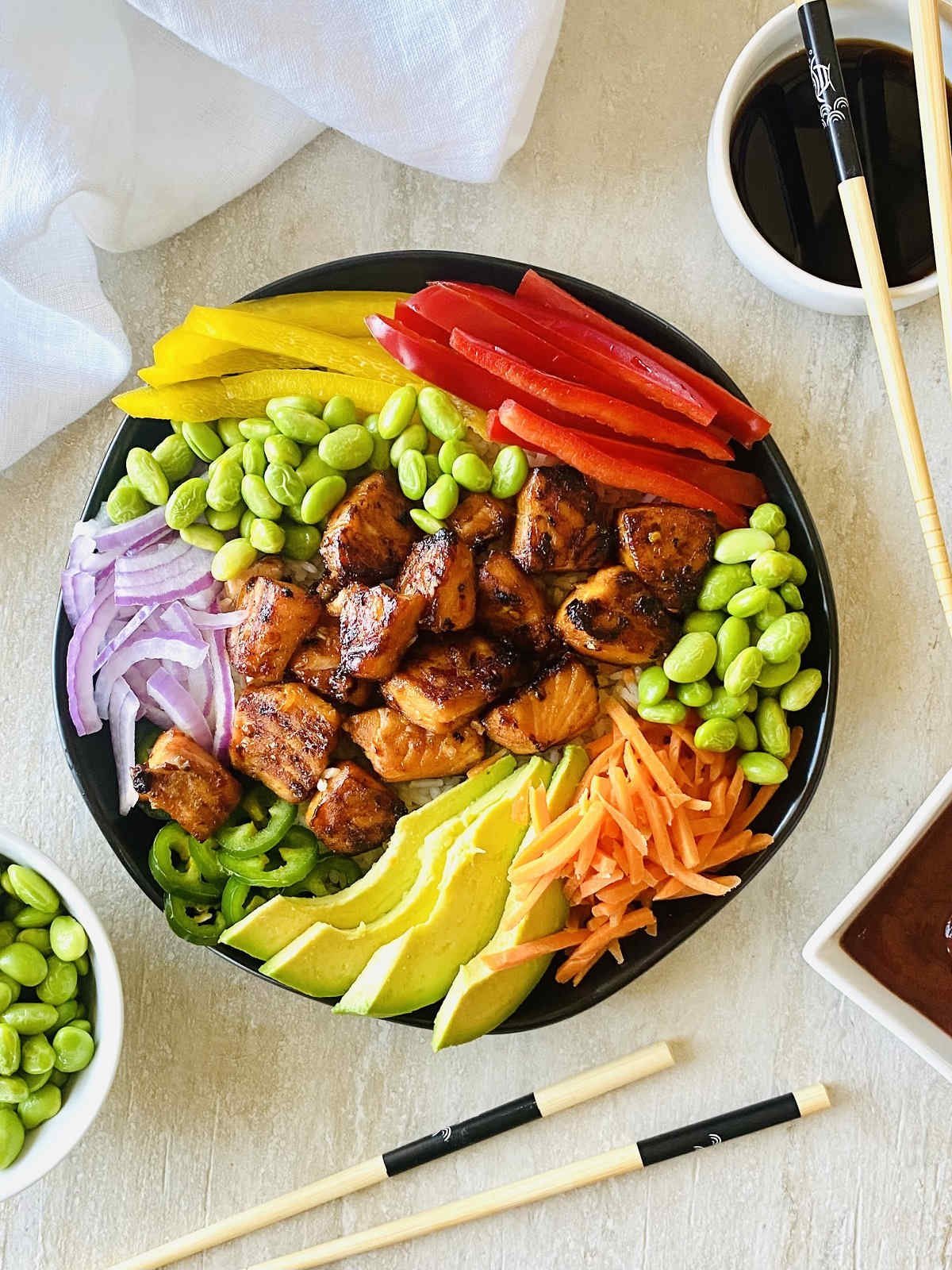 tik tok salmon rice bowl with sriracha, soy sauce, chili oil and edamame