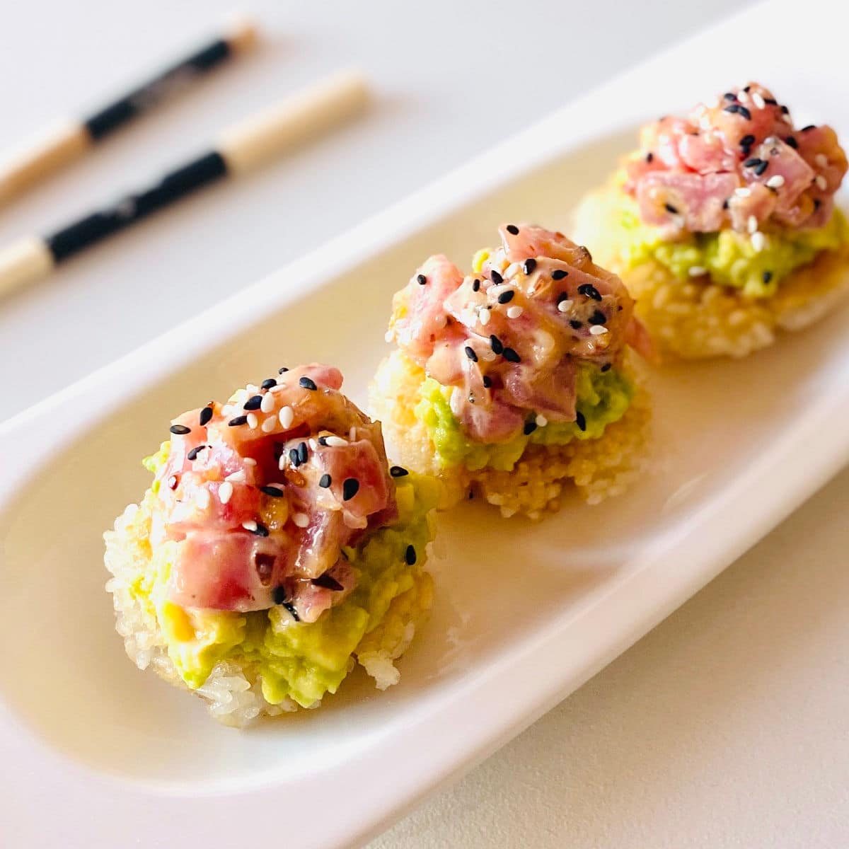 spicy tuna crispy rice on plate next to chopsticks