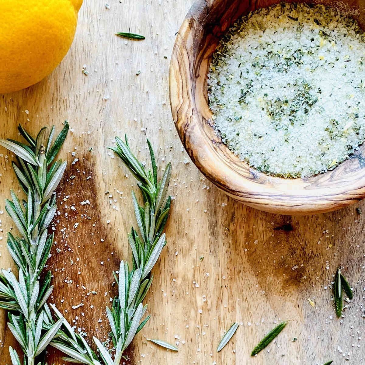 Rosemary salt in bowl next to lemon and rosemary