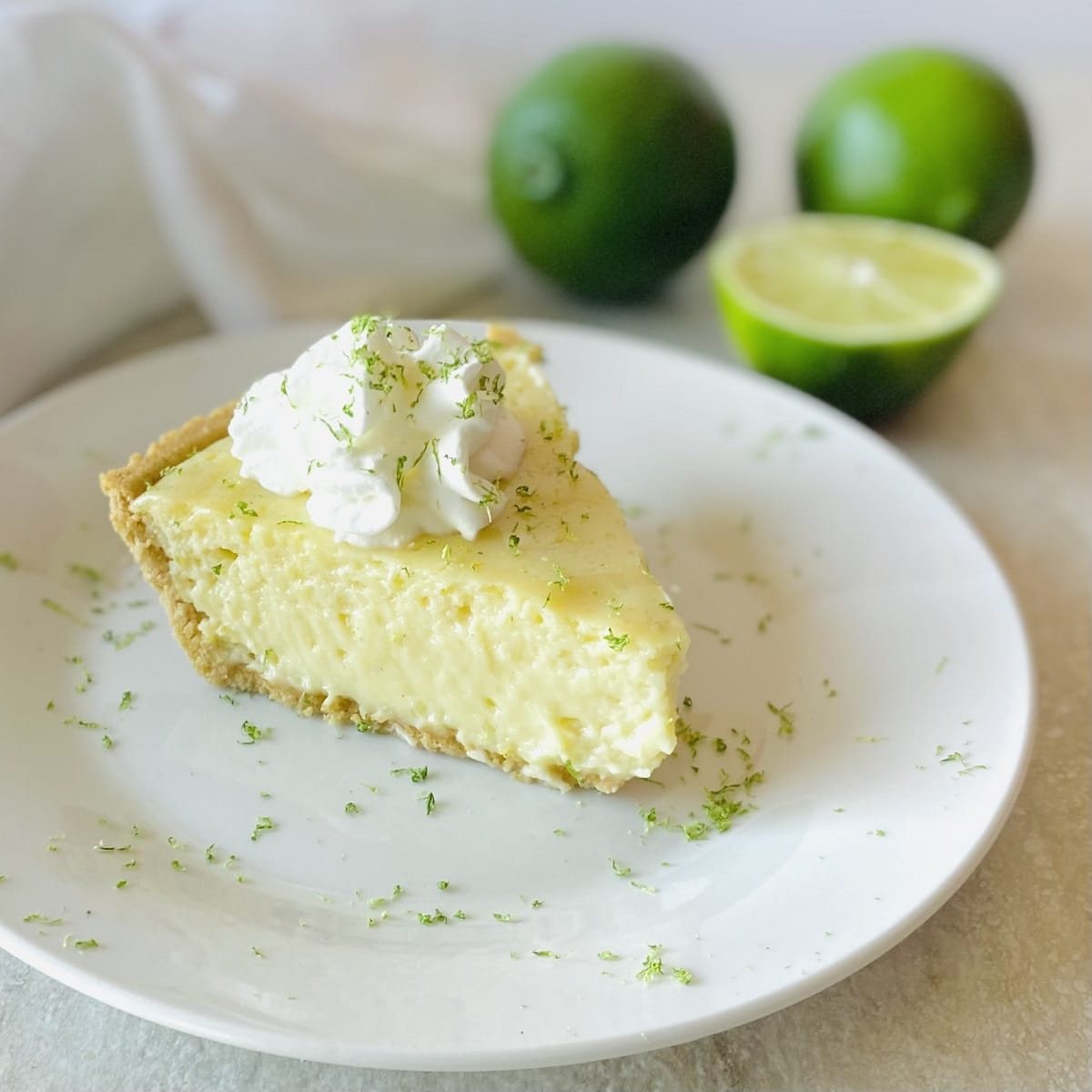 easy gluten free key lime pie on a plate next to limes