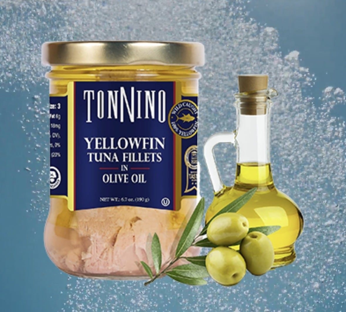 tonnino tuna in a jar next to a carafe of olive oil.