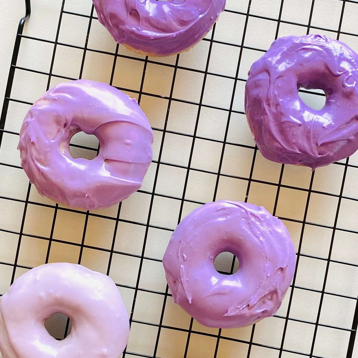 ube donuts on a cooling rack