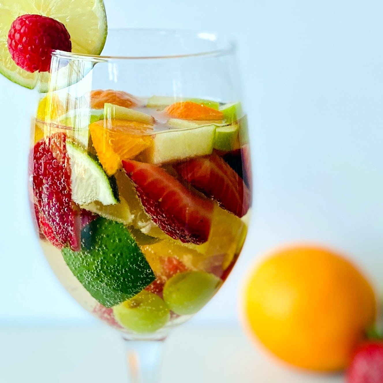 white-sangria-in-wine-glass-with-fruit-and-fruit-in-background