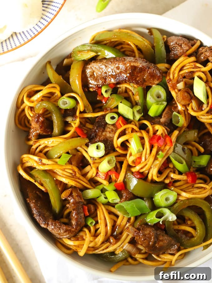 Sweet and Sticky Beef Noodle Stir Fry 2 Delicious Beef Stir Fry with noodles and a rich sticky sauce, garnished with fresh spring onions.