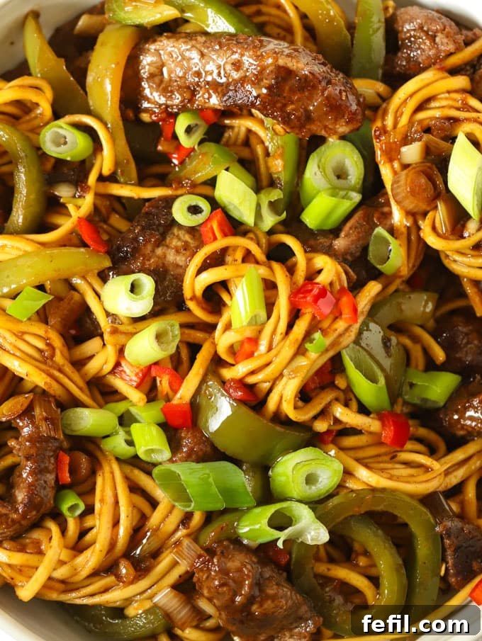 Sweet and Sticky Beef Noodle Stir Fry 3 Close-up of beef noodles with vibrant green peppers and a glossy sticky sauce, ready to be enjoyed.