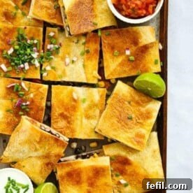 Chicken Quesadillas cut into squares with lime and salsa.