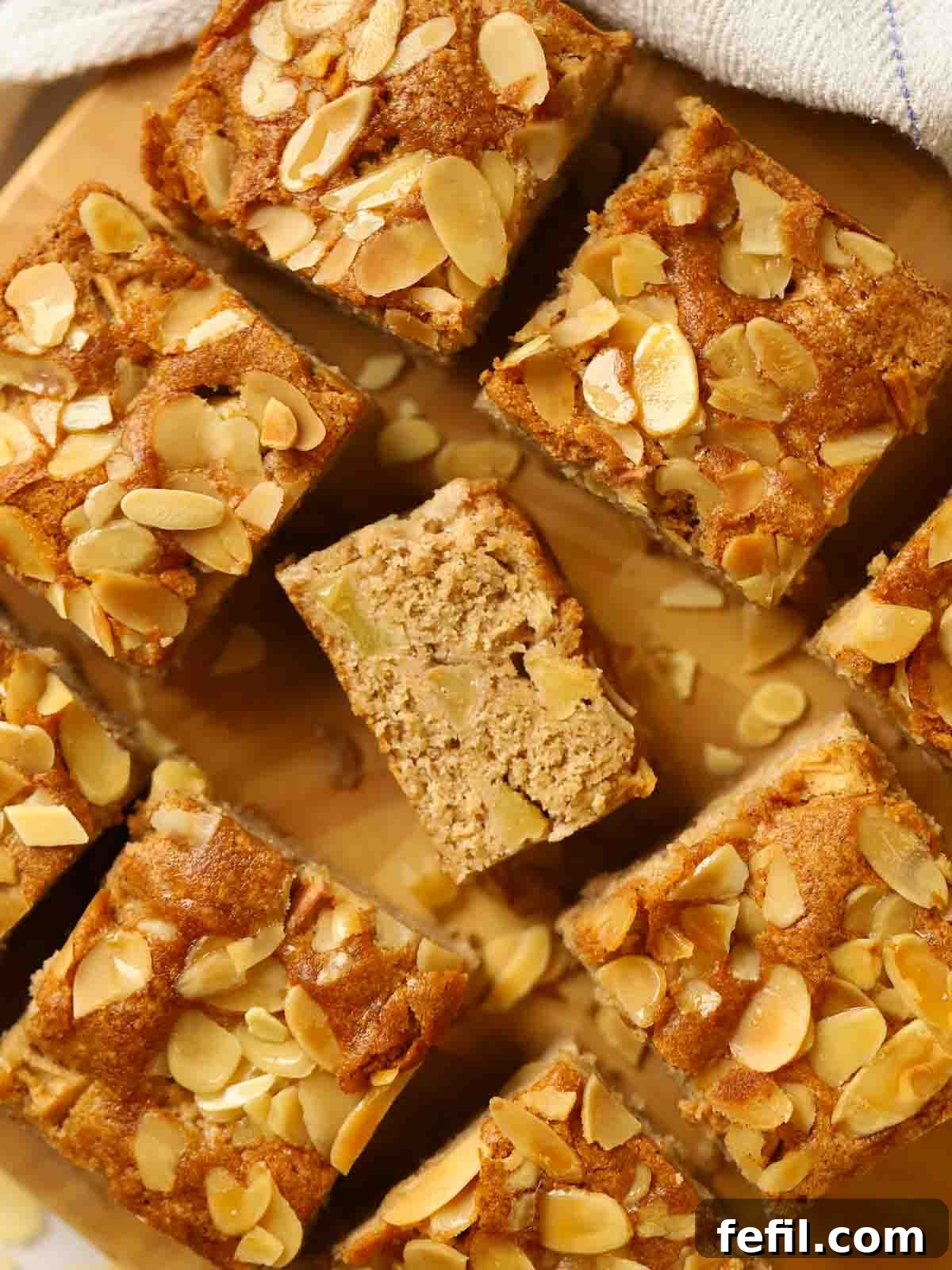 Homestyle Apple Cake 2 Six small squares of beautifully golden apple cake on a wooden board, ready to be served.