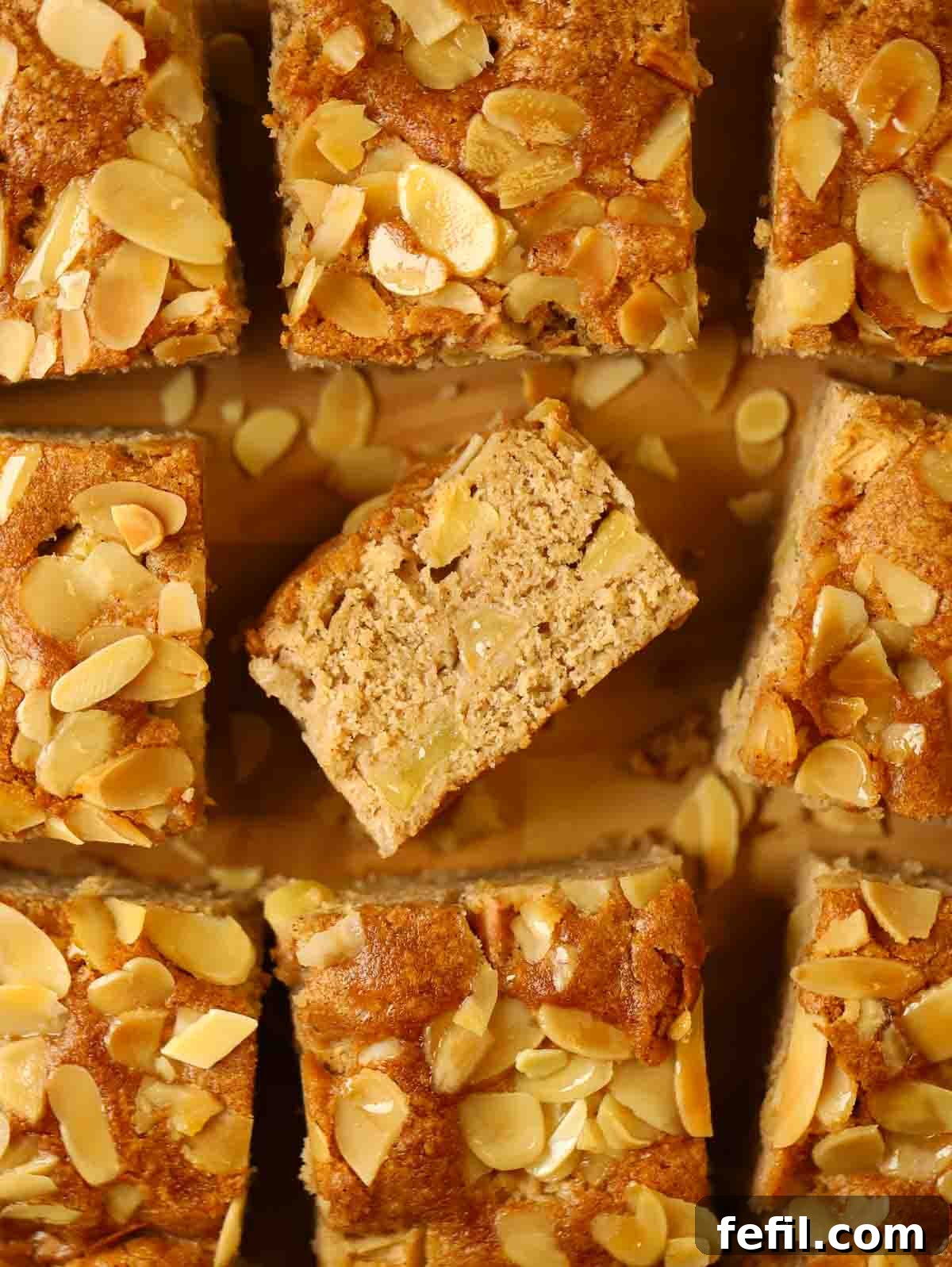 Homestyle Apple Cake 3 Close-up of apple cake squares on a board, with one square tilted to reveal the moist interior with apple chunks.