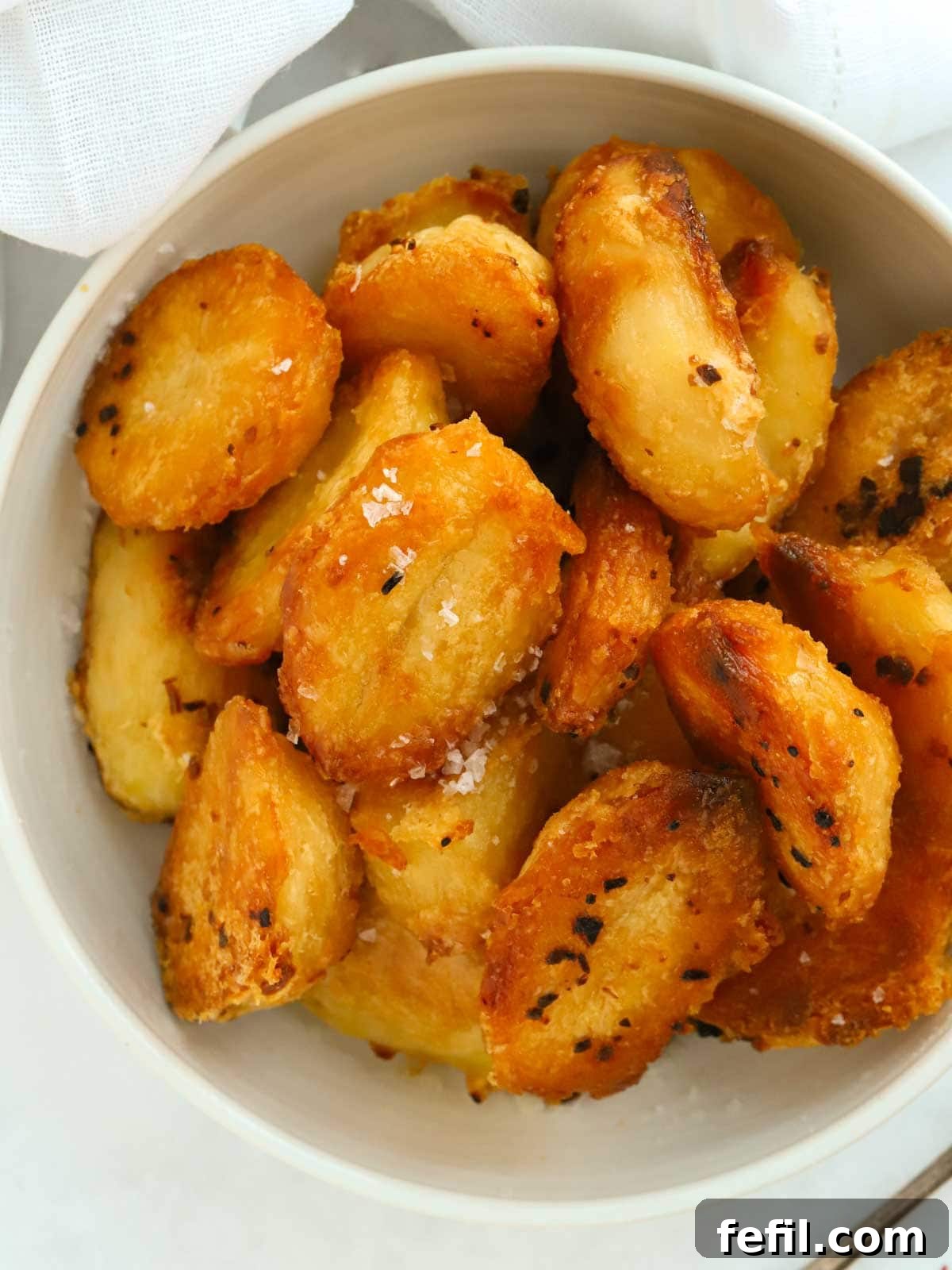 Close up of a bowl of delicious golden roast potatoes. This is an easy recipe.