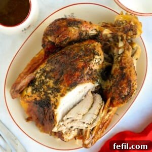 A beautifully roasted turkey on the Christmas dinner table, garnished for serving.