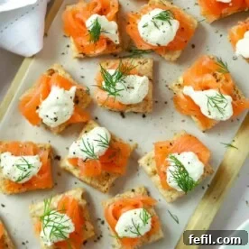 Perfect party food on a serving board. Smoked Salmon Canapés topped with creme fraiche and dill, ready to be served.
