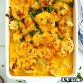 Large bowl of creamy, golden Easy Cauliflower Cheese, fresh out of the oven, bubbling and delicious.