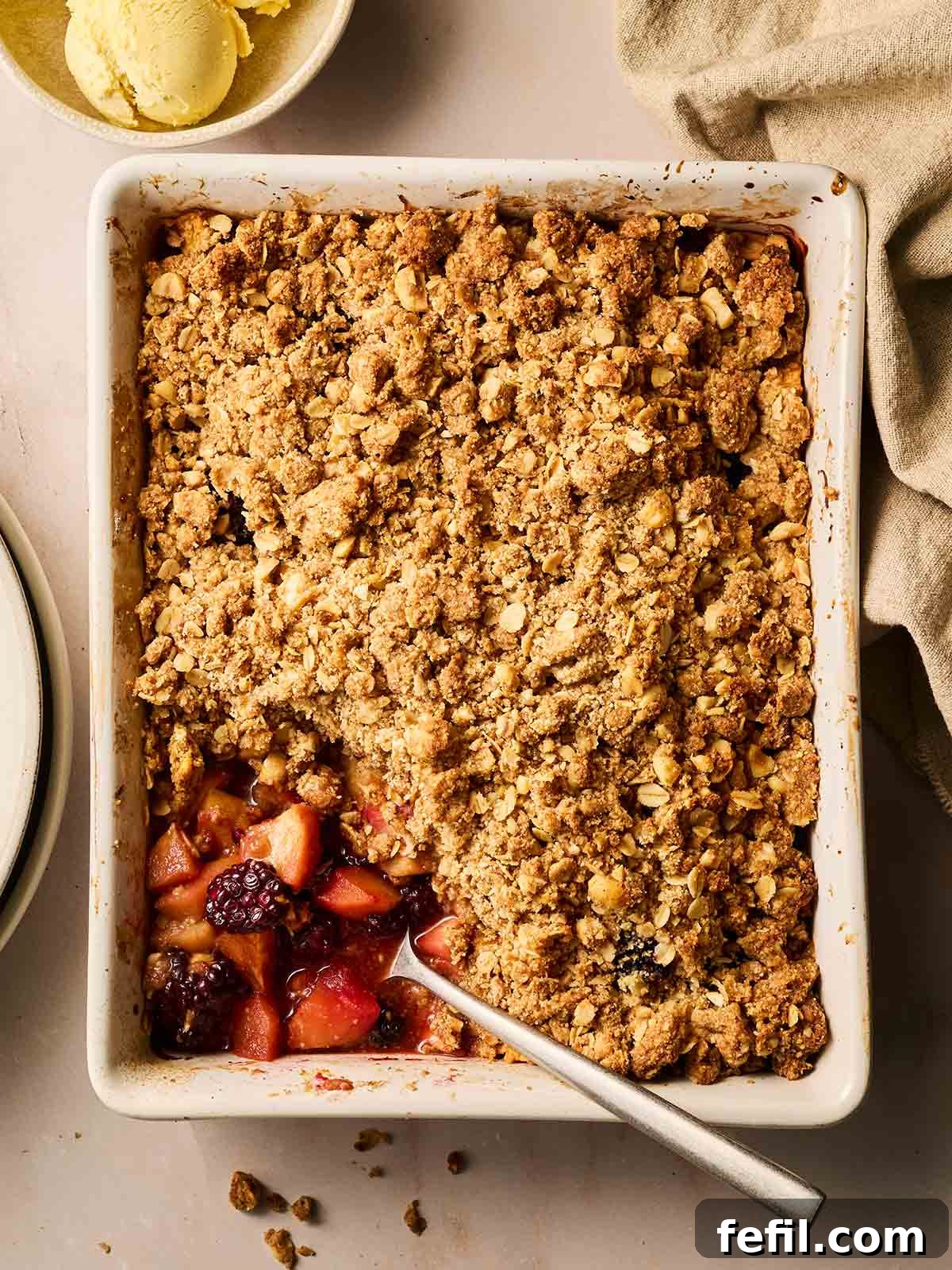 A perfectly baked Apple and Blackberry Crumble in a rustic dish, ready to be served on a cozy autumn table.