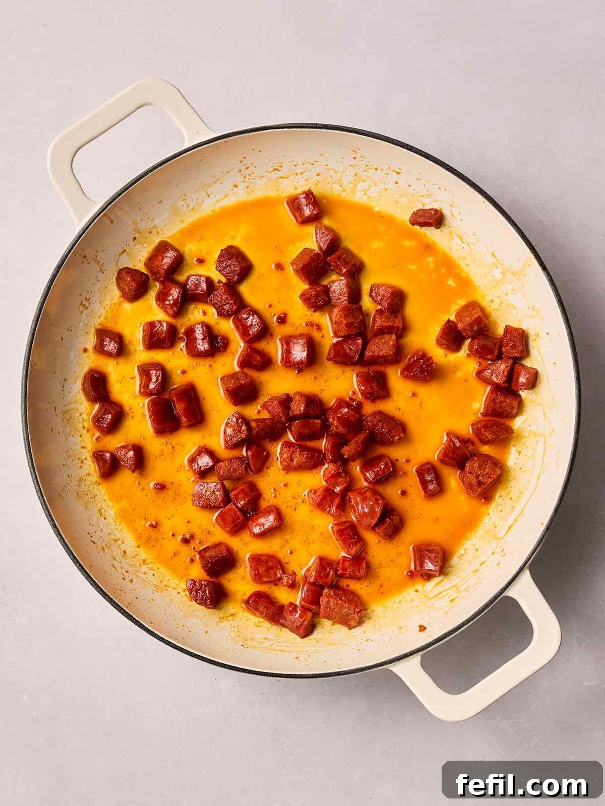 A non-stick frying pan, glistening with the rich, red oils released from cubes of chorizo, as they fry to a perfect crisp over medium-high heat.