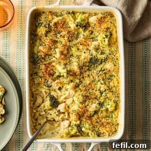 Herb Butter Chicken Pasta 9 An oven dish filled with a one-pan Chicken Kiev Pasta, showcasing the creamy orzo, chicken pieces, broccoli, and a golden breadcrumb topping, ready to be served.