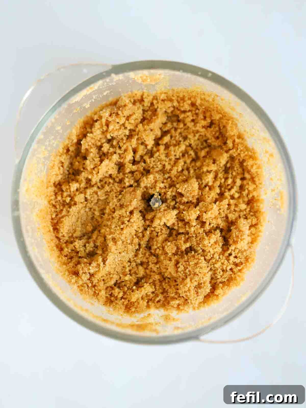 Crushed biscuit in a food processor for step 1 in the recipe for Nutella Cheesecake.