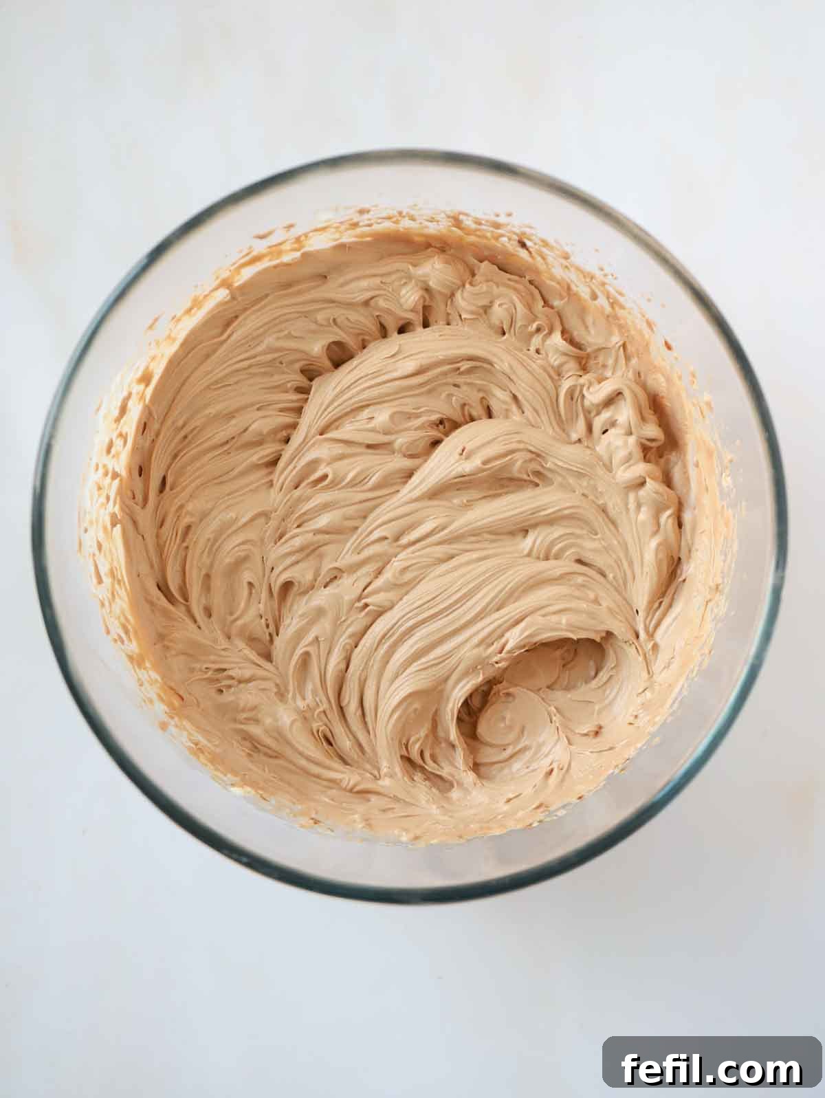 Whipping cream, sugar, cream cheese and lemon juice in a glass bowl for for step 3 in the recipe for Nutella Cheesecake.